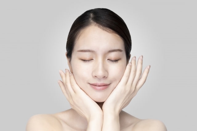 目を閉じながら顔全体にオールインワンジェルを着ける女性