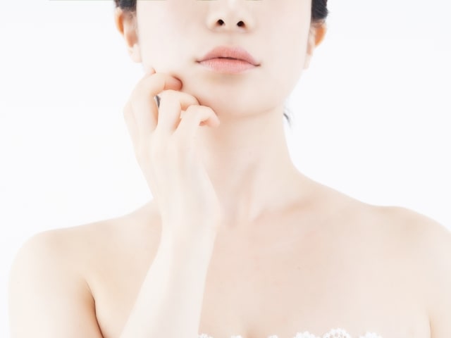 右手で顎を触れる女性